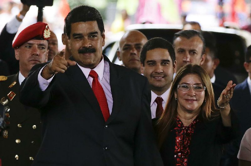 Venezuelan President Nicolas Maduro and first lady Cilia Flores acknowledge supporters Tuesday at a Caracas ceremony after the U.S. denounced his election Sunday as a “sham.”  
