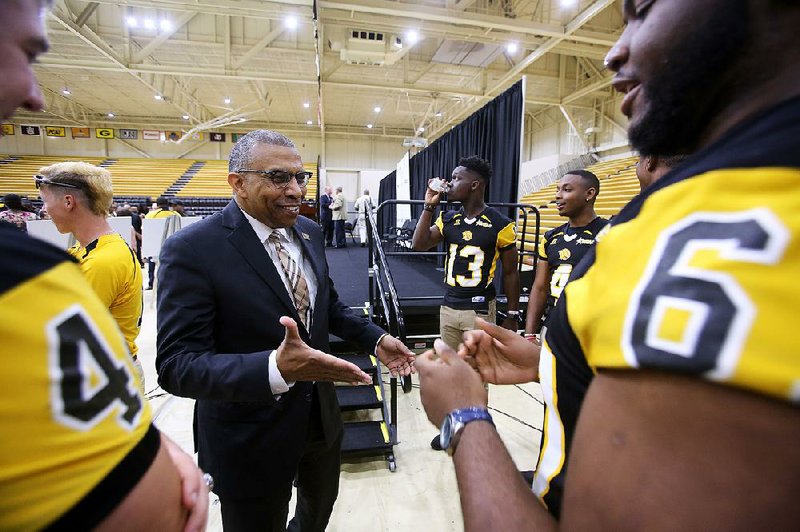 University of Arkansas at Pine Bluff Chancellor Laurence B. Alexander talks with football players Tuesday after the announcement that Simmons Bank is giving the school $2.5 million for improvements to its football and baseball facilities. 