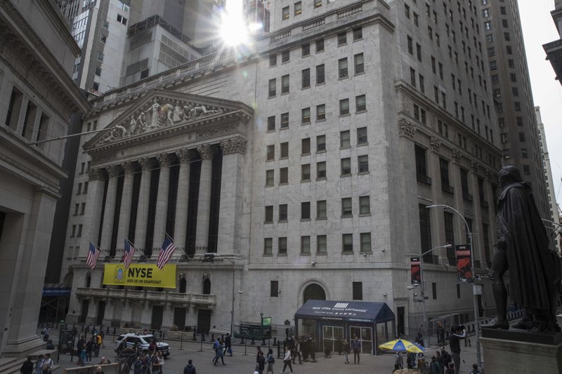 FILE- In this April 24, 2018, file photo, the sun shines from behind the New York Stock Exchange in New York. (AP Photo/Mary Altaffer, File)