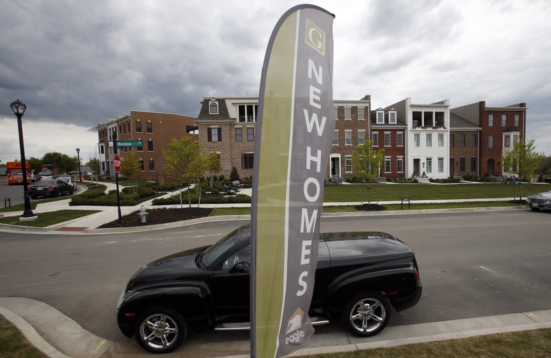 FILE- In this April 23, 2018, file photo, advertising signs point out completed new homes, homes under construction as well as lots for new homes in Glen Allen, Va. On Wednesday, May 23, the Commerce Department reports on sales of new homes in April. (AP Photo/Steve Helber, File)