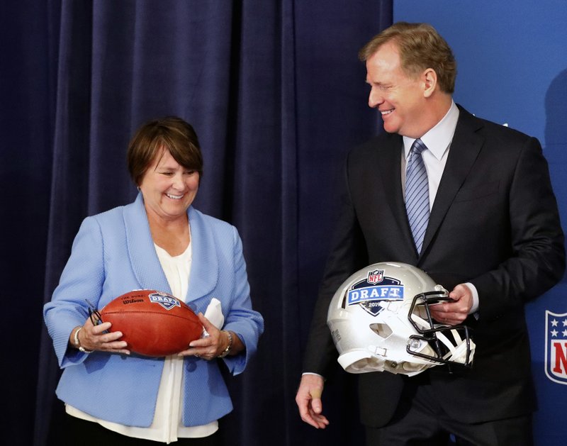 Tennessee Titans owner Amy Adams Strunk holds a football as she and NFL commissioner Roger Goodall prepare for a photo after it was announced that Nashville will host the 2019 NFL draft during the NFL owner's spring meeting Wednesday, May 23, 2018, in Atlanta. (AP Photo/John Bazemore)