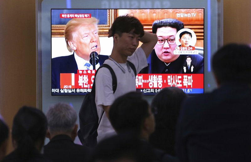 People watch a TV screen showing file footage of U.S. President Donald Trump, left, and North Korean leader Kim Jong Un during a news program at the Seoul Railway Station in Seoul, South Korea, Thursday, May 24, 2018. North Korea carried out what it said is the demolition of its nuclear test site Thursday, setting off a series of explosions over several hours in the presence of foreign journalists.The signs read: " North Korea demolishes nuclear test site ." (AP Photo/Ahn Young-joon)