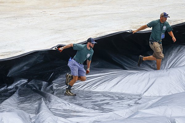 Members of the grounds crew remove the tarp during a rain delay in the seventh inning of a Southeastern Conference Tournament NCAA college baseball game between Georgia and Mississippi, Thursday, May 24, 2018, in Hoover, Ala. (AP Photo/Butch Dill)

