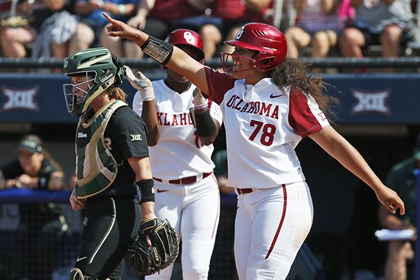 Oklahoma's Jocelyn Alo (78) celebrates in front of Baylor catcher Carlee Wallace, left, after scoring in the first inning of the championship game of the Big 12 softball tournament in Oklahoma City, Saturday, May 12, 2018. (AP Photo/Sue Ogrocki)

