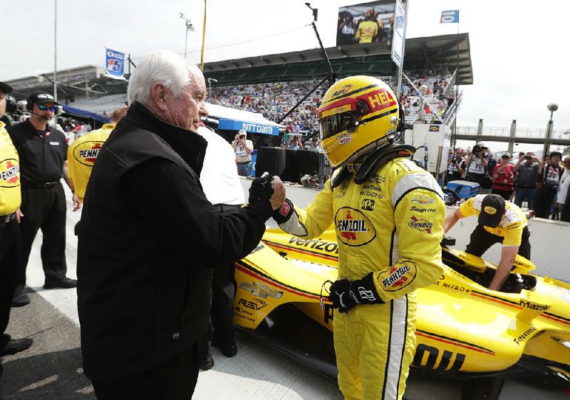 Car owner Roger Penske (left) congratulates driver Helio Castroneves after his qualifying run for the Indianapolis 500 on Saturday. On Sunday, Penske will have four cars in the Indy 500, as well as three in NASCAR’s Coca-Cola 600. 

