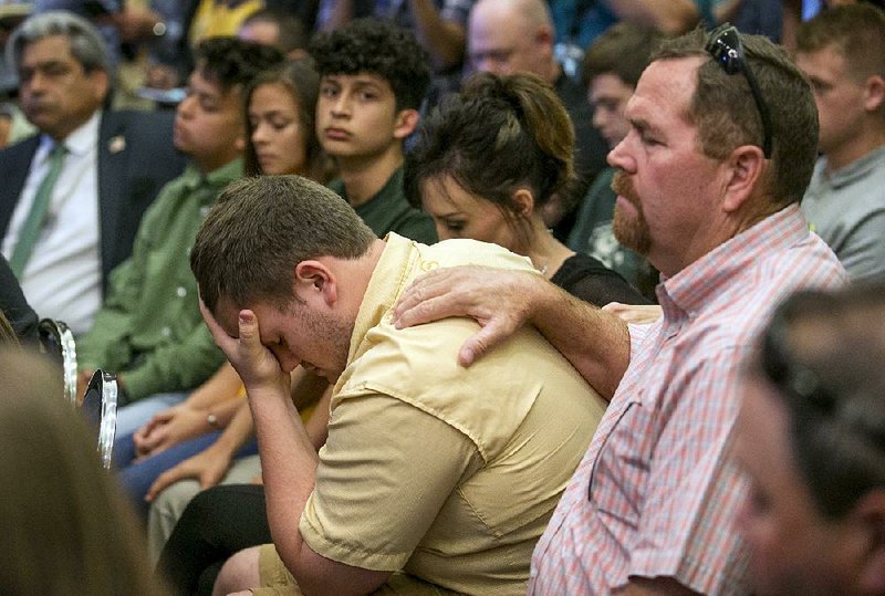 Santa Fe, Texas, High School student Aaron Chenowith is comforted by his father, Richard Chenowith, during a discussion with Gov. Greg Abbott on school shootings Thursday at the Texas state Capitol in Austin. 