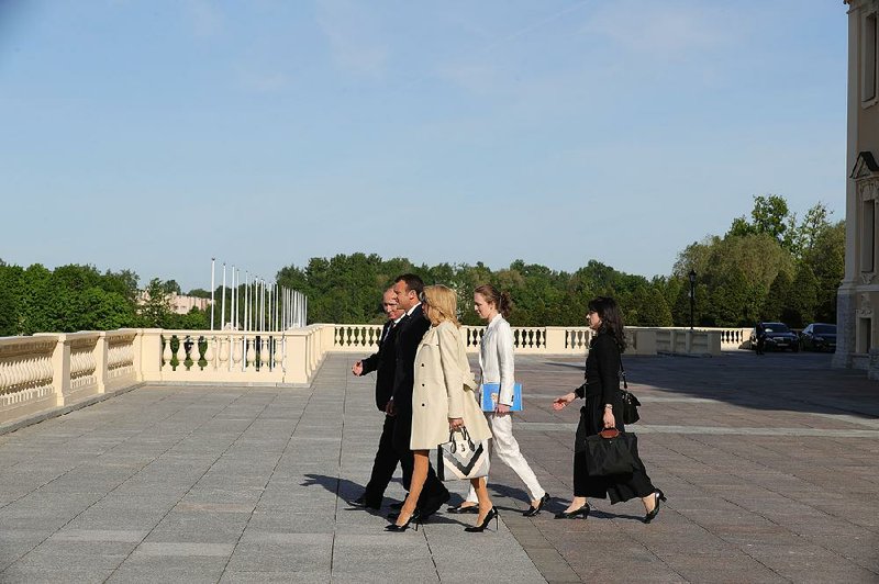 Russian President Vladimir Putin walks with French President Emmanuel Macron, Macron’s wife, Brigitte, and their aides Thursday at Konstantin Palace outside St. Petersburg, Russia. 