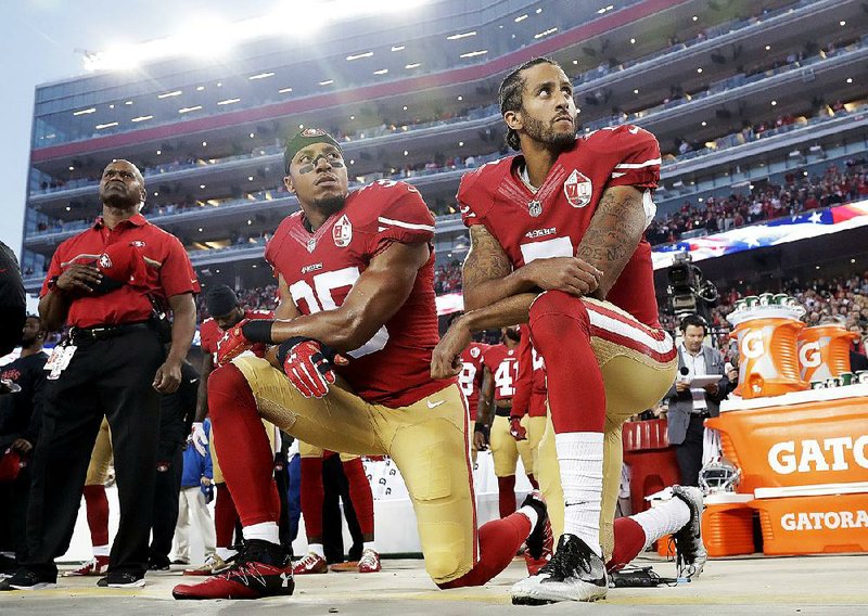 Then-San Francisco 49ers quarterback Colin Kaepernick (right) and safety Eric Reid kneel during the national anthem before a game against the Los Angeles Rams in the 2016 season. The NFL has approved new rules regarding national anthem protests, but the league has also given teams the option of developing their own workplace rules. Many players have taken that as a way for teams to threaten them with fines, suspensions or worse should they carry on with the protests.  