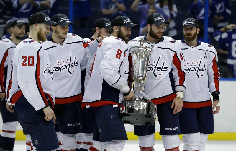 Washington Capitals left wing Alex Ovechkin (8) holds the Prince of Wales trophy with teammates after the Capitals defeated the Tampa Bay Lightning 4-0 during Game 7 of the NHL Eastern Conference finals hockey playoff series Wednesday, May 23, 2018, in Tampa, Fla. (AP Photo/Chris O'Meara)