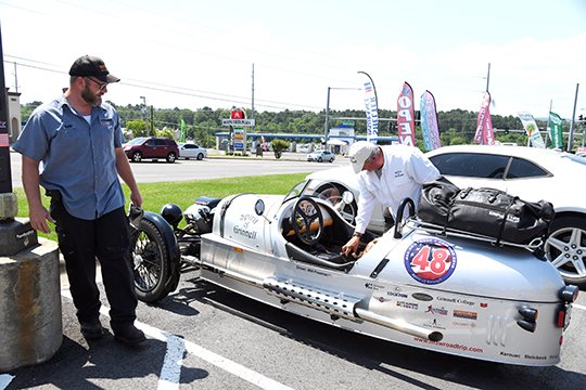 The Sentinel-Record/Grace Brown EYE-CATCHING: Seth Stuart, left, looks on as Will Freeman of Iowa prepares the Spirit of Grinnell, a 2017 Morgan 3-wheeler for the drive to Helena on Thursday. Freeman is taking the 3-wheeler through all 48 states of the continental United States and plans to conclude his trip in August.