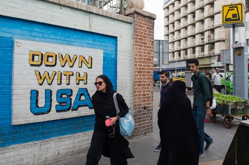 Pedestrians pass a wall mural proclaiming 'Down With The USA' on a street in Tehran, Iran, on May 9, 2018. MUST CREDIT: Bloomberg photo by Ali Mohammadi.
