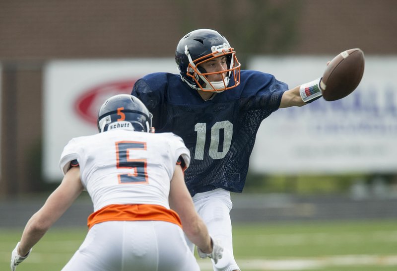 NWA Democrat-Gazette/BEN GOFF @NWABENGOFF Jeb Brown (10), quarterback, tosses the ball under pressure from Isaiah Tibbs Thursday, May 24, 2018, as Rogers Heritage holds it's Spring scrimmage at Gates Stadium.