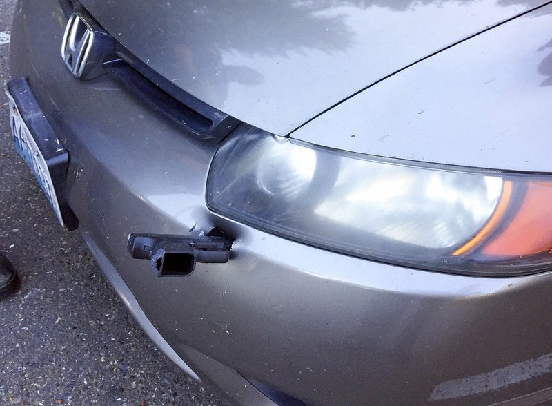 This Wednesday, May 23, 2018 photo provided by the Washington State Patrol shows a handgun embedded in the front bumper of a car in Lakewood, Wash. 