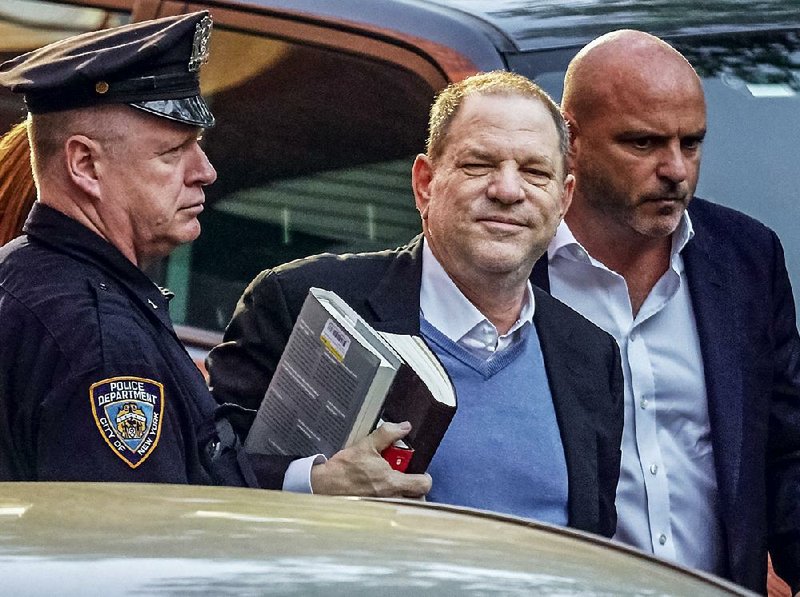 Film producer Harvey Weinstein arrives Friday at a police station in New York to surrender to authorities to face charges of rape and sexual abuse.  