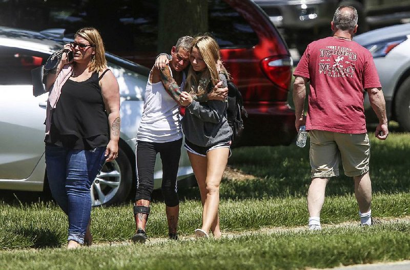 People gather outside Noblesville High School in Noblesville, Ind., where students were bused after a shooting Friday at the nearby middle school.  