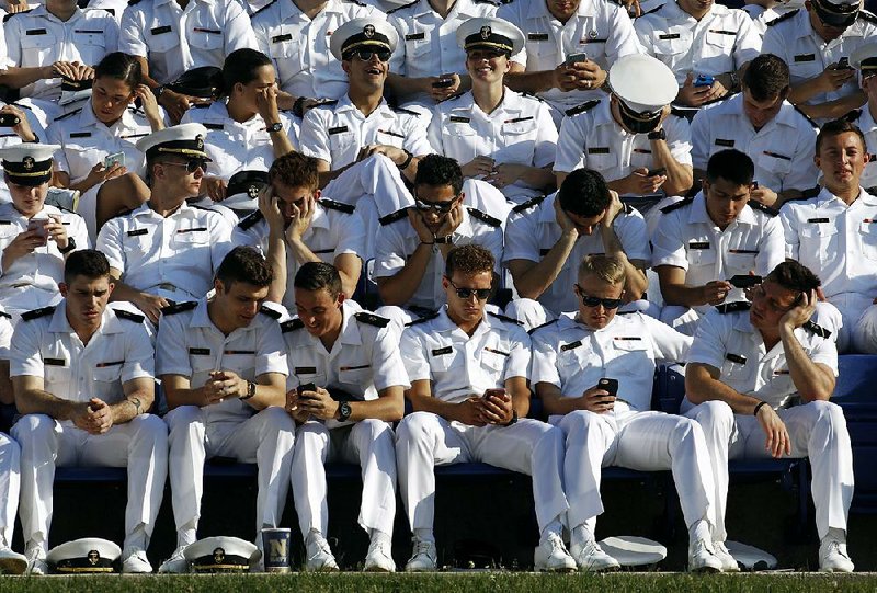 U.S. Naval Academy midshipmen wait Friday for the academy’s graduation and commissioning ceremony to begin.  