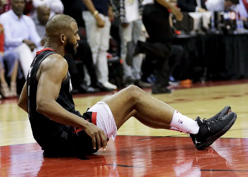 Houston Rockets guard Chris Paul sits on the floor after being hurt during the second half of Thursday’s Western Conference finals Game 5 against the Golden State Warriors in Houston. The Rockets will be without their star guard for tonight’s Game 6. 