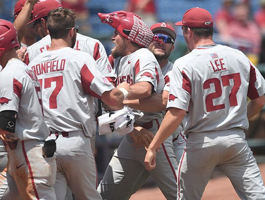 NWA Democrat-Gazette/J.T. Wampler HOG WILD: Arkansas redshirt junior infielder Hunter Wilson, center, received the Hog hat from his teammates Friday in Hoover, Ala., after hitting a grand slam in the ninth inning to give the Razorbacks a decisive 8-2 lead over No. 1 Florida in the SEC Tournament.