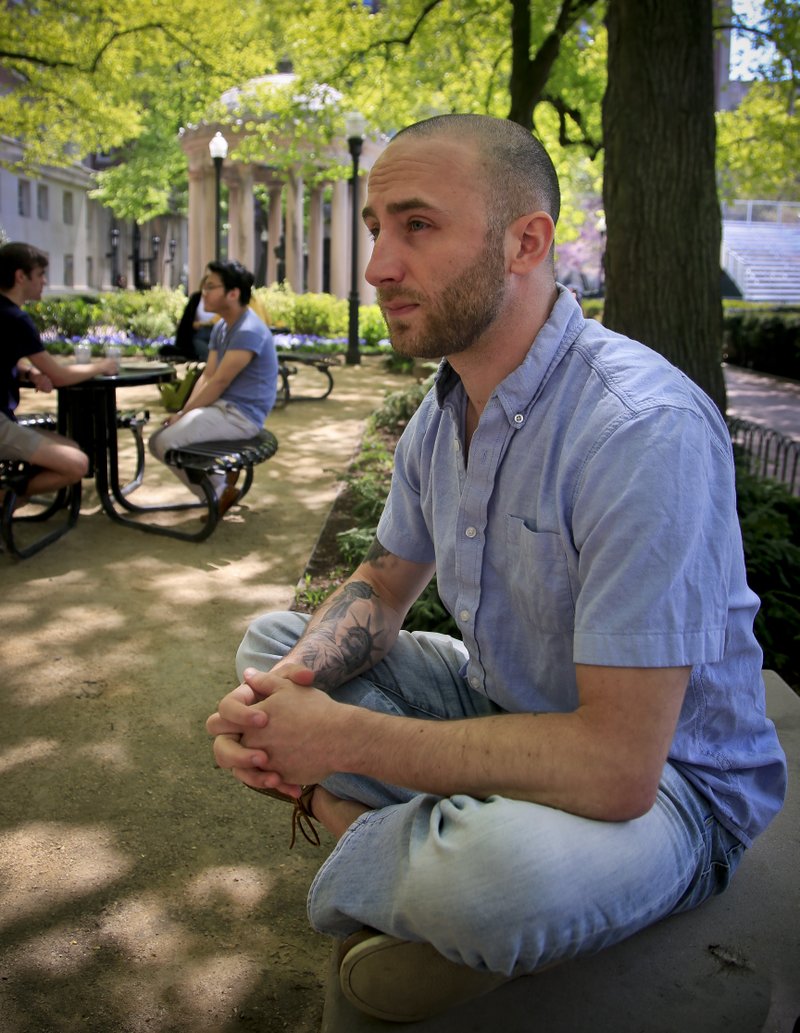 In this May 9, 2018 photo, Iraq War veteran Kristofer Goldsmith, sits in a campus park after his last final exam of the semester at Columbia University in New York.  (AP Photo/Bebeto Matthews)