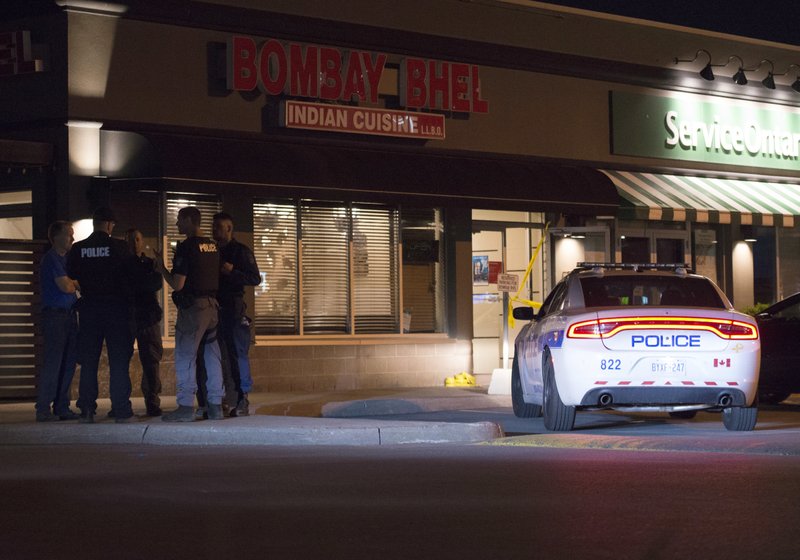 Police stand outside the Bombay Bhel restaurant in Mississauga, Canada Friday May 25, 2018. Canadian police say an explosion set off deliberately in a restaurant has wounded a number of people. (Doug Ives/The Canadian Press via AP)