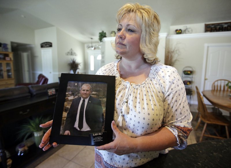 In this July 13, 2016 file photo, Laurie Holt holds a photograph of her son Josh Holt at her home, in Riverton, Utah. Josh Holt has been released from a jail in Venezuela after spending nearly two years behind bars on weapons charges. Utah Sen. Orrin Hatch said on Twitter Saturday, May 26, 2018, that Joshua Holt had been released. President Donald Trump tweeted that it was “good news,” adding that Holt “should be landing in D.C. this evening and be in the White House, with his family, at about 7:00 P.M.” (AP Photo/Rick Bowmer, File)