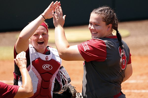 Oklahoma's Lea Wodach, left, and Paige Parker react after retiring Arkansas in an NCAA college championship super regional softball game Saturday, May 26, 2018, in Norman, Okla. (Steve Sisney/The Oklahoman via AP)

