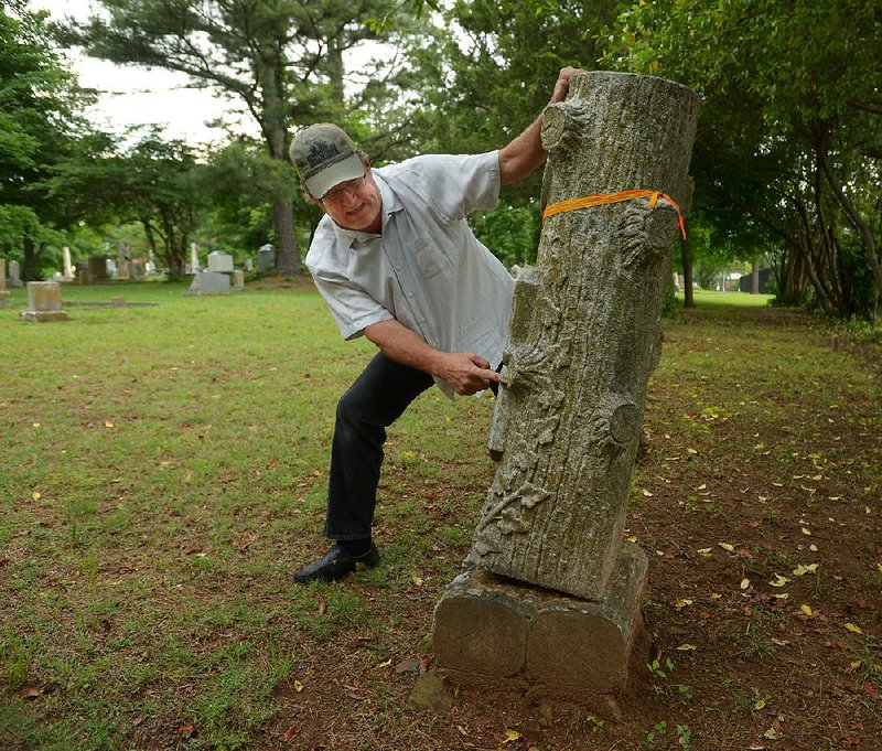 Bob Young, administrator of the Fayetteville Evergreen Cemetery Association, demonstrates how easy it is to topple an unsecured Woodmen of the World tombstone. “These are in cemeteries all over everywhere, and nobody’s addressing this issue,” Young said.  
