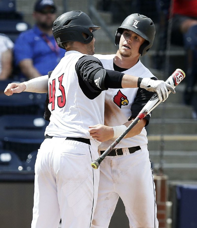 Louisville’s Devin Mann (right) gets a hug from teammate Logan Wyatt after hitting a home run during the eighth inning Saturday as the Cardinals beat Pittsburgh 5-2 in Durham, N.C., to advance to the ACC Tournament championship game. 