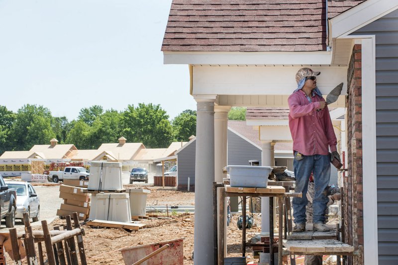 NWA Democrat-Gazette/SPENCER TIREY Mario Gueveca works May 18 on a house in the Mansions, a multifamily development off Mill Street in Springdale. The face of housing in Springdale is changing with different kinds of upscale developments.