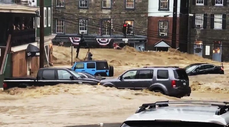 Floodwaters rush through Main Street on Sunday in Ellicott City, Md. 