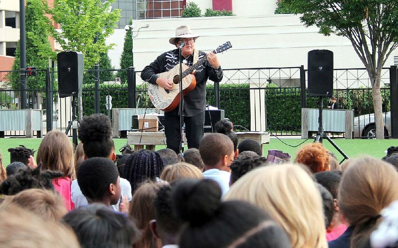 Colorado singer-songwriter Jim Salestrom performs Wednesday on the playground of eStem Charter School in Little Rock. 
