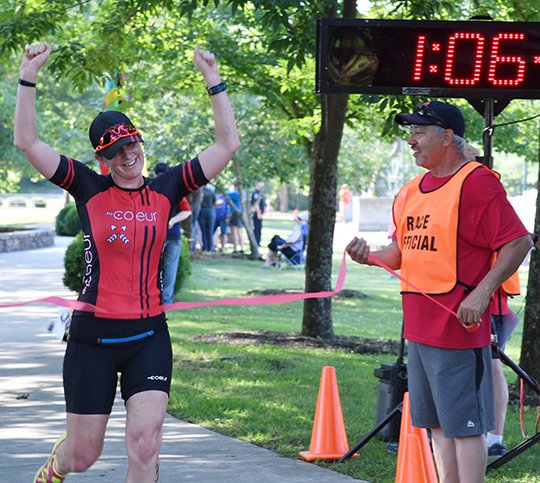 The Sentinel-Record/Grace Brown SWEET VICTORY: Chenin Doiron, of Monroe, La., celebrates as she crosses the finish line and wins 19th annual Du for the Parks duathlon women's division along the Hot Springs Greenway Trail on Sunday. Doiron had a time of 1:06:20.