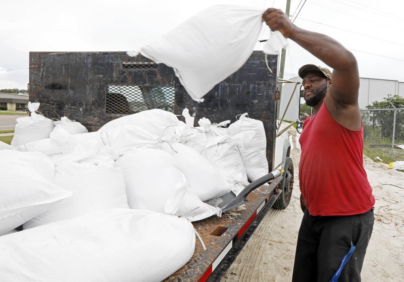 Travis Lee loads filled sand bags onto a truck bed as he and a co-worker prepare to protect the storage company they work at, Saturday, May 26, 2018 in Gulfport, Miss. They and many other Gulf Coast residents are preparing for Subtropical Storm Alberto to make its way through the Gulf of Mexico to land. The slow moving storm is threatening to bring heavy rainfall, storm surges, high wind and flash flooding this holiday weekend. (AP Photo/Rogelio V. Solis)
