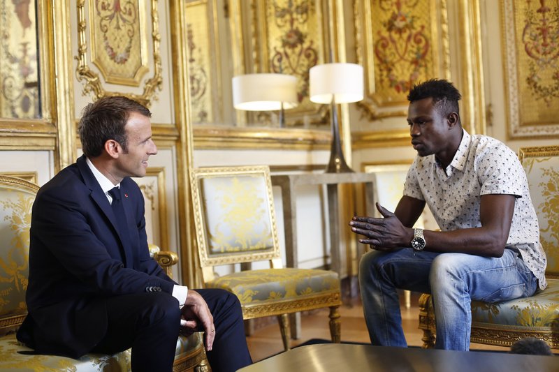 French President Emmanuel Macron, left, meets with Mamoudou Gassama, 22, from Mali, at the presidential Elysee Palace in Paris, Monday, May, 28, 2018. Mamoudou Gassama living illegally in France is being honored by Macron for scaling an apartment building over the weekend to save a 4-year-old child dangling from a fifth-floor balcony. (AP Photo/Thibault Camus, Pool)

