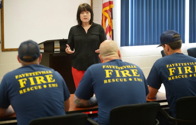 Valerie McDermott, Employee Assistance Program counselor for the University of Arkansas for Medical Sciences, speaks Thursday to a group of Fayetteville firefighters to gather suggestions for what they want to discuss for an upcoming work session at the department’s Central Fire Station. 