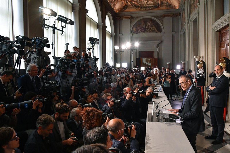 New premier-designate Carlo Cottarelli, right, addresses the media after meeting with Italian President Sergio Mattarella, at the Quirinale Presidential Palace, in Rome, Monday, May 28, 2018. Italy's president has formally asked economist Cottarelli to try to form a government after quashing the hopes of the euroskeptic 5-Star Movement and the League to form Western Europe's first populist government. (Alessandro Di Meo/ANSA via AP)