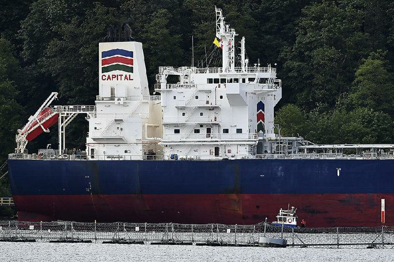An oil tanker dwarfs an accompanying security vessel Tuesday at Kinder Morgan Inc.’s Trans-Mountain pipeline terminal in Burnaby, British Columbia.  