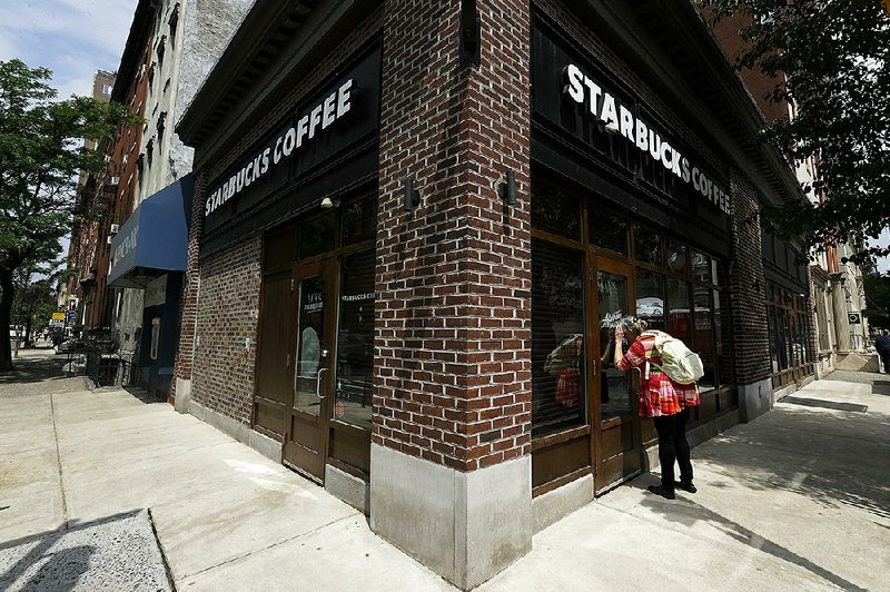 A woman peers into a Starbucks coffee shop in Philadelphia that was among more than 8,000 of the chain’s stores that closed Tuesday for anti-bias training.   
