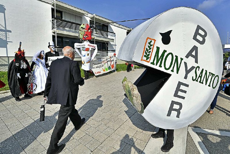 Activists protest Friday outside Bayer AG headquarters in Bonn, Germany, against Bayer’s planned $66 billion takeover of Monsanto Co. The companies reached a settlement Tuesday with the Justice Department that clears the last major hurdle to the agreement.   
