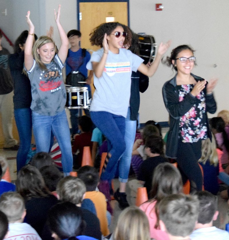 Westside Eagle Observer/MIKE ECKELS Kaylee Morales (right), Desi Meek and Tabby Tilley lead students in a round of cheers during the Operation Dream Big celebration at Decatur Northside Elementary in Decatur May 15.