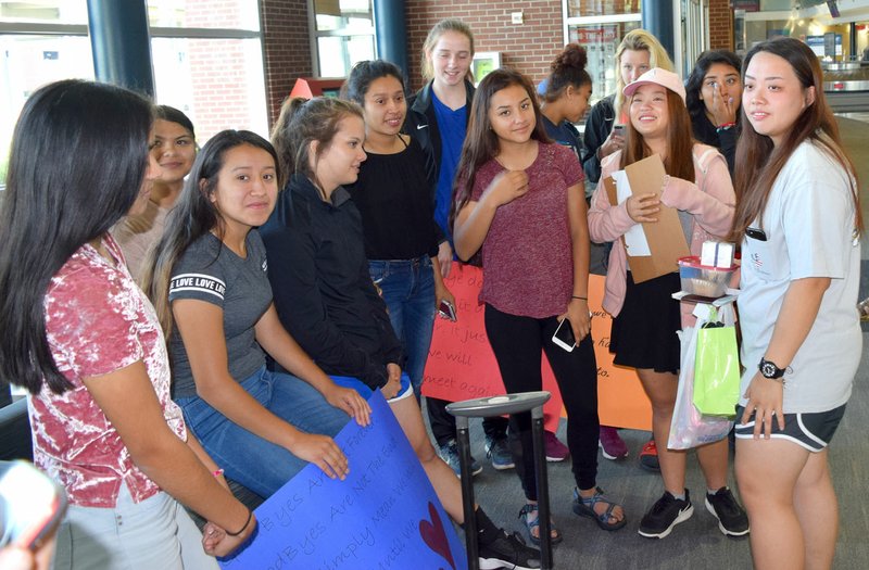 Airbus Dungsungnoen (far right) talks to Stephanie Sandoval (left) as a large group of friends gather in the lounge area at XNA in Highfill to say goodbye. Airbus, a foreign exchange student at Decatur High School, was on her way home to Bangkok, Thailand, on May 22.