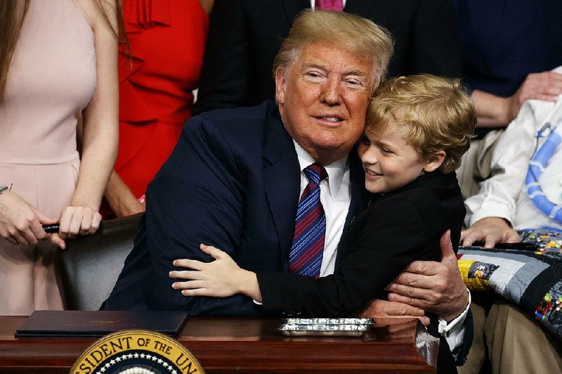 President Donald Trump hugs 8-year-old muscular dystrophy patient Jordan McLinn after signing the legislation Wednesday at the White House. 