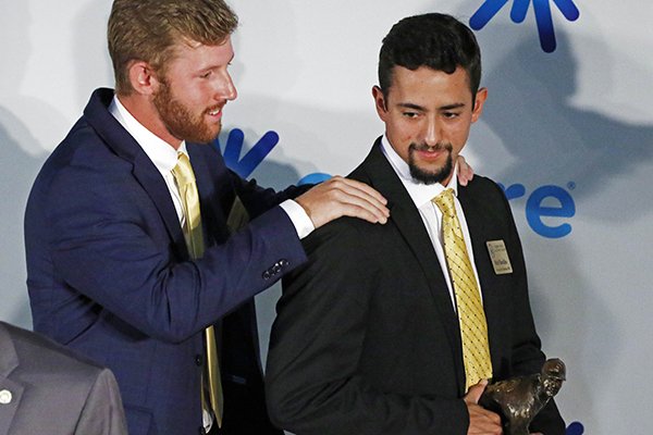 Southern Mississippi infielder and finalist Luke Reynolds, left, gives teammate junior right-handed pitcher Nick Sandlin a congratulatory shoulder-shake after Sandlin is presented the C Spire Ferriss Trophy as the state's top collegiate baseball player, Monday, May 21, 2018, in Jackson, Miss. (AP Photo/Rogelio V. Solis)

