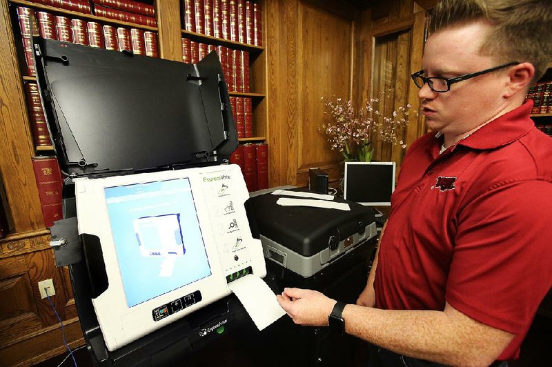 State election coordinator Josh Bridges explains how the new voting equipment works Friday at the state Capitol. Chris Powell, a spokesman for the secretary of state’s office, said the equipment won’t be connected to the Internet and can’t be hacked. 