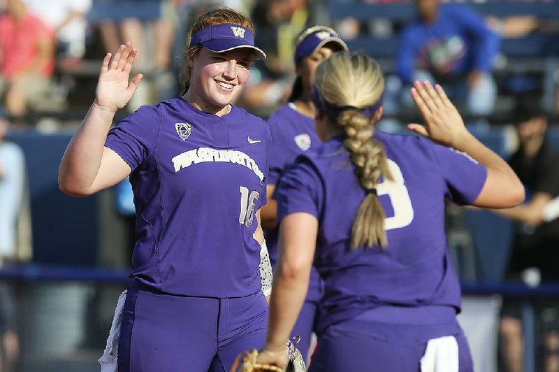 Washington pitcher Gabbie Plain (left) celebrates with teammate Taylor Van Zee during the Huskies’ 6-2 victory over Oregon on Friday at the Women’s College World Series in Oklahoma City. 