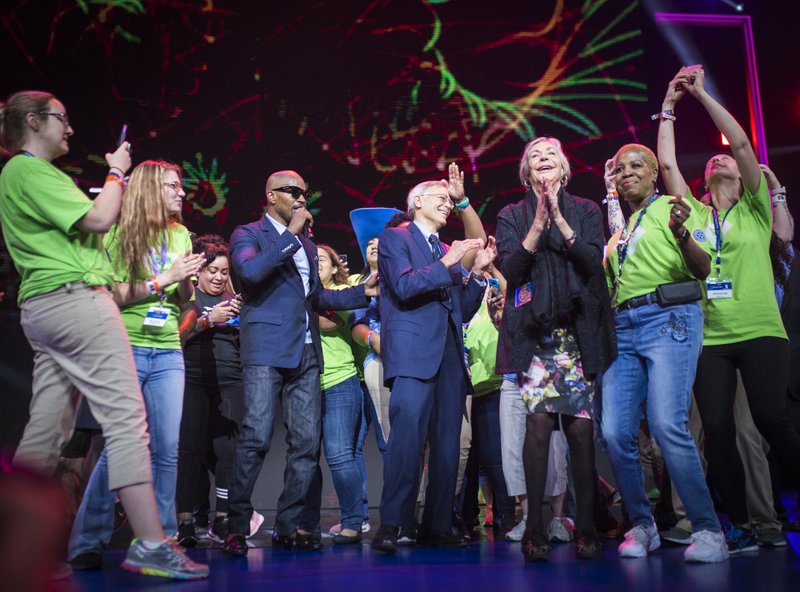 Jamie Foxx performs Friday with Jim Walton (center) and Alice Walton (center right) during the annual Walmart shareholders meeting at the University of Arkansas’ Bud Walton Arena in Fayetteville.