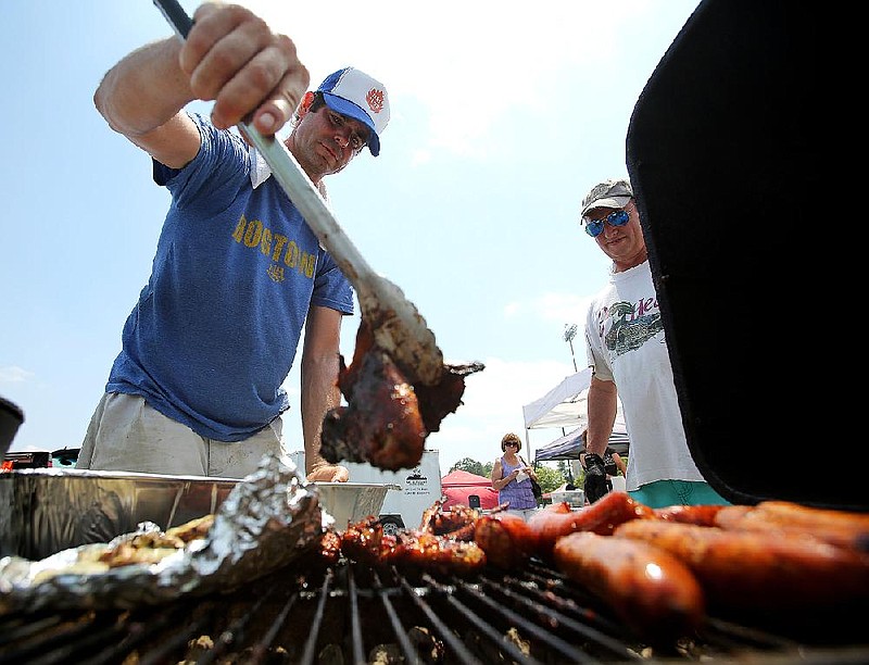 FILE — Harry Harris of North Little Rock flips chicken wings on the grill during the 2018 PK Grills Cookout competition at War Memorial Stadium in Little Rock in this June 2, 2018 file photo. (Arkansas Democrat-Gazette/THOMAS METTHE)