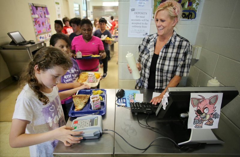 NWA Democrat-Gazette/DAVID GOTTSCHALK Theresa Warford (right), cafeteria assistant manager at Owl Creek School, watches Thursday as Summer Cousin, a fourth-grader, punches in her lunch number during lunch at the Fayetteville school. Owl Creek School will be participating in the Fayetteville Public Schools Summer Lunch & Snack Program beginning Monday through Aug. 8. The program is open to anyone 18 years or younger. In addition to other sites in the city, a new mobile site will be at the Fayetteville Public Library.