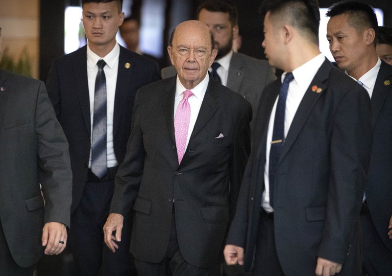 U.S. Commerce Secretary Wilbur Ross, center, leaves his hotel in Beijing, Saturday, June 2, 2018. U.S. Commerce Secretary Wilbur Ross has arrived in Beijing for talks on China's promise to buy more American goods after Washington revived tensions by renewing its threat of tariff hikes on Chinese high-tech exports. (AP Photo/Mark Schiefelbein)