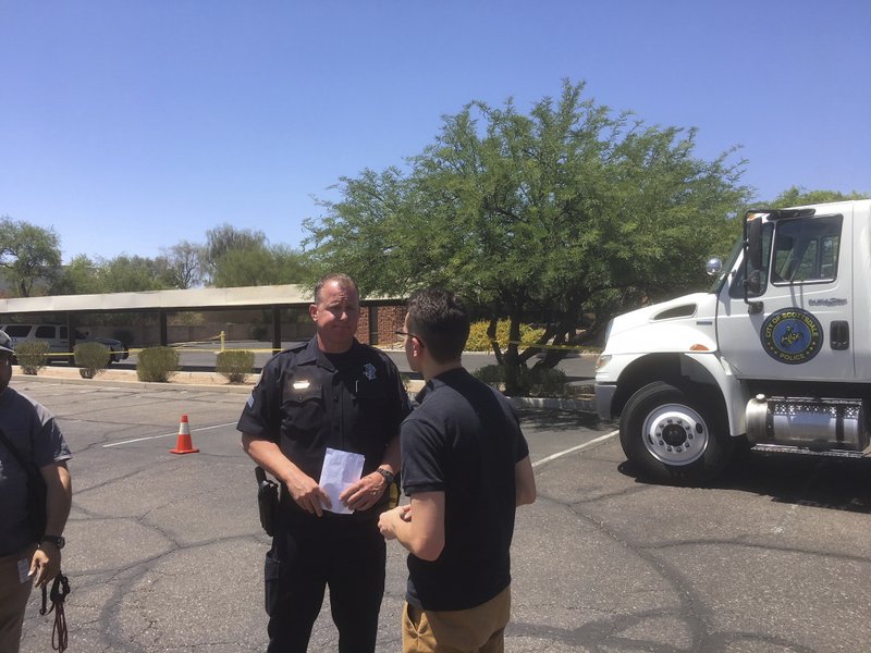 Scottsdale Police Sgt. Ben Hoster speaks to a member of the news media at the scene of a fatal shooting in Scottsdale, Ariz., on Saturday, June 2, 2018. The shooting death on Thursday of Dr. Steven Pitt, a prominent forensic psychiatrist who assisted in high-profile murder cases including serial killings in Phoenix is connected to the slayings of two paralegals, said authorities, who were looking into a possible fourth homicide Saturday. (AP Photo/Paul Davenport)